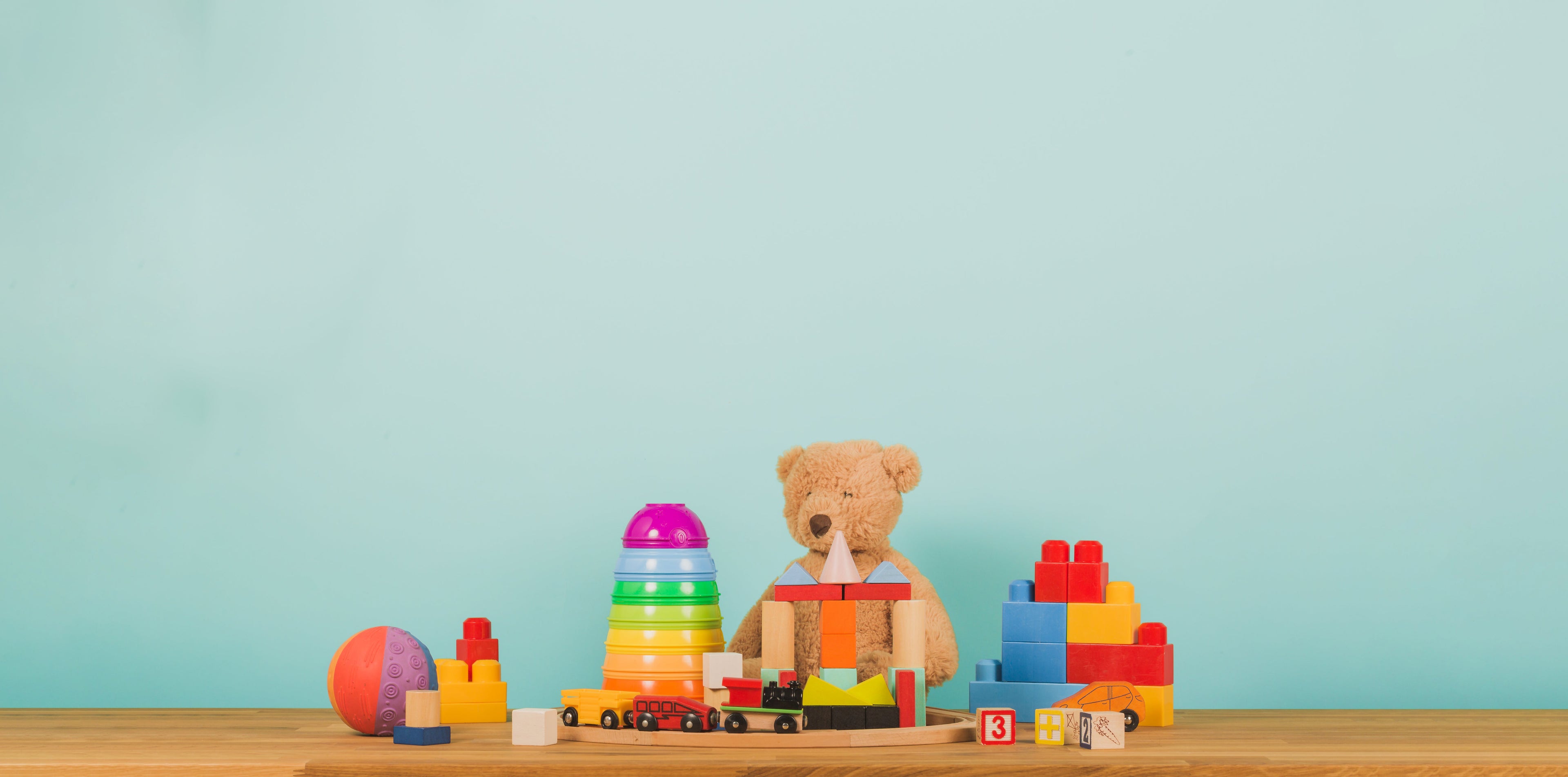 A colorful wooden toy train alongside vibrant toy blocks arranged on a table, perfect for children's playtime